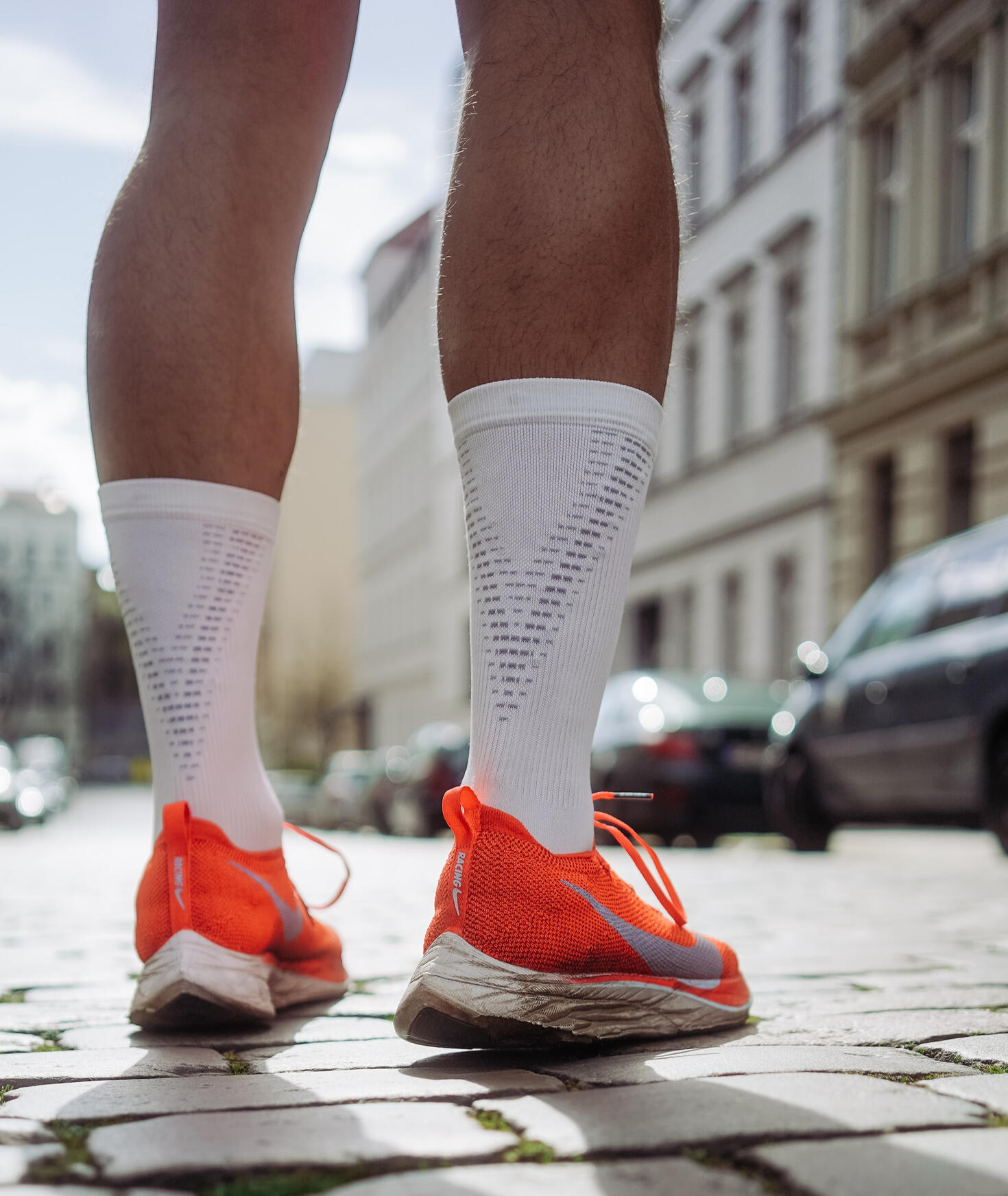 Photo of person wearing orange Nike running shoes standing on pavement, by Florian Kurrasch on Unsplash